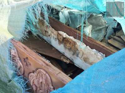Alcuni feretri quasi integri nascosti sotto un telo in plastica azzurra